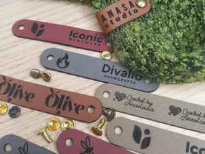 Customized 2.5 x 0.5 in Faux Leather Product Tags With Rivets Personalized Tags for Knitting and Crochet, Cute Labels Handmade Perfect for Hats Beanies Scarves & More (25 Labels)